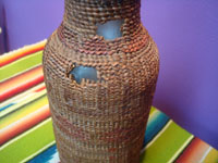 Native American Indian antique baskets, a Tlingit hand-blown glass bottle with wonderful weaving around it, c. 1900. Photo of another side of the bottle showing some of the damage.