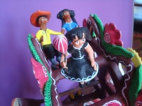 Mexican vintage folk art, and Mexican vintage pottery and ceramics, a wonderful pottery ferris wheel filled with happy people and very colorful decorations, Ocumicho, Michoacan, c. 1980's. Closeup of some of the happy people on the ferris wheel.