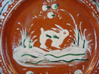 Mexican vintage pottery and ceramics, a Bandera-ware pottery plate with a wonderful bunny, Tlaquepaque, c.1930. This type of pottery is called bandera (Spanish for "flag") because of the colors of red, green, and white, the colors of the Mexican flag. Very fine hand-painted decorations on this piece of vintage Mexican folk art.  Closeup photo.