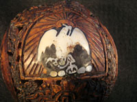 Mexican vintage folk art, a finely carved coconut with scenes from the Mexican Revolution of 1910, c. 1925-35. The carved coconut has the Mexican national emblem of the eagle and snake inlaid in abalone. Closeup photo of Mexican flag inlaid in abalone.