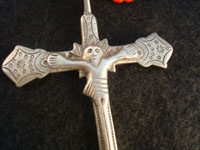 Mexican vintage silver jewelry, a Mexican or Guatemalan silver cross, c. 17th-18th century. This is a colonial era devotional cross showing significant indigenous, pre-hispanic influence. Closeup photo of silver cross.