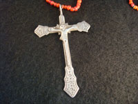Mexican vintage silver jewelry, a Mexican or Guatemalan silver cross, c. 17th-18th century. This is a colonial era devotional cross showing significant indigenous, pre-hispanic influence. Closeup photo of silver cross.