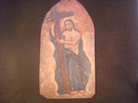 Mexican vintage devotional art, a tin retablo of Christ clutching the cross, c. 1850-1900. The images are hand-painted on tin and are exquisite. The retablo is arch-shaped, resembling a typical stained-glass window in a church. Main photo of retablo.