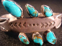 Native American Indian vintage silver jewelry, a Navajo sterling silver bracelet with 6 beautiful turquoise stones, c. 1920. Made from ingot silver, with wonderful early stamping and file marks. This is a treasure for the collector of Native American Indian jewelry! Closeup of Navajo bracelet.
