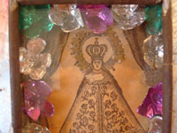Mexican vintage devotional art, a very old print depicting Our Lady of Juquila, in a very decorative tinwork and glass nicho, c. 1930. A closeup photo of the retablo.