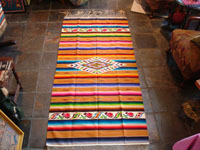 Mexican vintage textiles and sarapes, a lovely Saltillo sarape with a wonderful center diamond of silk, c. 1920's. The predominant color is a lovely golden tan, with very colorful intermittant bands.