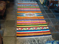 Mexican vintage textiles and sarapes, a lovely Saltillo sarape with a wonderful center diamond of silk, c. 1920's. The predominant color is a lovely golden tan, with very colorful intermittant bands. Another photo showing the entire saltillo sarape.