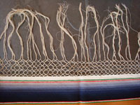 Mexican vintage textiles and sarapes, a lovely Saltillo sarape with a wonderful center diamond of silk, c. 1920's. The predominant color is a lovely golden tan, with very colorful intermittant bands. A closeup photo of the fringe of the sarape.