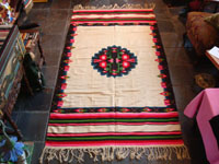 Mexican vintage textiles and sarapes, a lovely weaving from Oaxaca, c. 1940's. The textile is beautifully woven of fine wool. It has a white background with lovely flowers in the border and a beautiful center medallion.