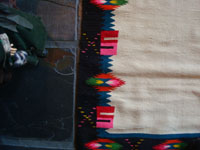 Mexican vintage textiles and sarapes, a lovely weaving from Oaxaca, c. 1940's. The textile is beautifully woven of fine wool. It has a white background with lovely flowers in the border and a beautiful center medallion. Photo of a side border.
