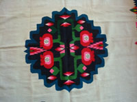 Mexican vintage textiles and sarapes, a lovely weaving from Oaxaca, c. 1940's. The textile is beautifully woven of fine wool. It has a white background with lovely flowers in the border and a beautiful center medallion. Photo of the center medallion.