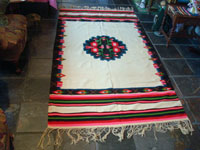 Mexican vintage textiles and sarapes, a lovely weaving from Oaxaca, c. 1940's. The textile is beautifully woven of fine wool. It has a white background with lovely flowers in the border and a beautiful center medallion. Another photo of the entire textile.