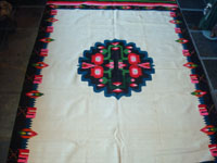 Mexican vintage textiles and sarapes, a lovely weaving from Oaxaca, c. 1940's. The textile is beautifully woven of fine wool. It has a white background with lovely flowers in the border and a beautiful center medallion.