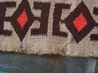 Native American Indian vintage textile, a Navajo Red-Mesa weaving, c. 1930-1940. The border shows a Tees Nos Pas influence. Very well woven with an eye-dazzler center design. A closeup photo of the edge of the weaving.