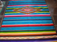 Mexican vintage sarape and textile, a Saltillo sarape, c. 1930's. Beautiful turquoise field. Very finely woven of wool and with a dynamite center diamond and end-bars of silk. Another view of the Saltillo sarape.