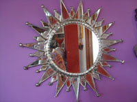 Mexican vintage tinwork art, a beautiful tinwork art mirror in the shape of a lovely sunburst, c. 1940's.  Main photo of the mirror.