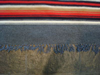 New Mexican vintage textile, a finely woven rug from the weaving center of Chimayo, New Mexico, c. 1930. This is from a very famous weaver, active from 1910-40, whose signature was the hummingbird in the center of this textile. Edge of textile.