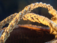 Native American Indian basket, a Northwest Coast twined purse, Tsimshian, c. 1900-10. Beautifully woven of cedar bark with geometric imbricated decoration and woven cedar bark handles. A closeup of the handles.