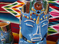 Mexican vintage pottery and ceramics, a pulque or punch set with pitcher and 5 mugs in the form of Aztec gods, c. 1940. Wonderful blue glaze with hand-painted faces and decorations on each piece. Closeup.