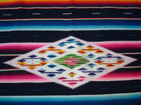 Mexican vintage sarapes and textiles, a lovely Saltillo sarape with a black background, c. 1930's. The sarape has a beautiful center medallion with silk, and the fringe is intact at both ends. Photo of the center diamond.