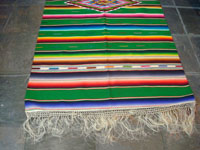 Mexican vintage sarapes and textiles, a beautiful Saltillo sarape with a green background and wonderful center diamond of silk, c. 1930's. Photo of the bottom end of the sarape showing the fringe at one end.