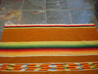 Mexican vintage sarapes and textiles, a rare and very beautiful Saltillo sarape with a tan/gold background and beautiful center medallion and rainbow border, c. 1900. A closeup showing one end of the Saltillo sarape.