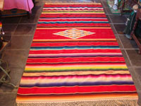 Mexican vintage textiles and sarapes, a beautiful Saltillo sarape with a red background, c. 1940's. The center medallion is spectacular, and the colors on both front and back are bright and vibrant. Main photo of the Saltillo sarape.