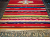 Mexican vintage textiles and sarapes, a beautiful Saltillo sarape with a red background, c. 1940's. The center medallion is spectacular, and the colors on both front and back are bright and vibrant. Main photo of the Saltillo sarape. Photo of one end of the Saltillo sarape.