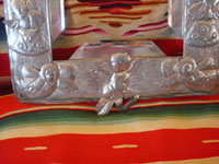 Mexican vintage tinwork-art, a beautifully stamped tin-work frame, c. 1950. The stamping work on this tin frame is magnificent, and features lovely cherubs and angels. Another closeup photo.