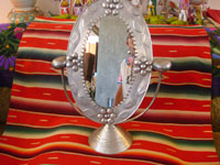 Mexican vintage tin art, a wonderfully stamped tin-work mirror, c. 1945. The mirror swivels up and down. It is extremely beautiful and very well-done! Another photo of the entire tin-art mirror.