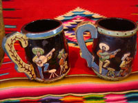 Mexican vintage pottery and ceramics, a wonderful pair of pottery mugs, with musicians, couples dancing, men drinking their tequila, all in relief and with beautiful animation and colors against a black background, Tonala or Tlaquepaque, Jalisco, c. 1930's.  Photo of the second side of the mugs.