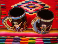Mexican vintage pottery and ceramics, a wonderful pair of pottery mugs, with musicians, couples dancing, men drinking their tequila, all in relief and with beautiful animation and colors against a black background, Tonala or Tlaquepaque, Jalisco, c. 1930's.  Another angle of the mugs.