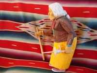 Photo, side view of Navajo wood carving by Johnson Antonio of elderly woman with cane.