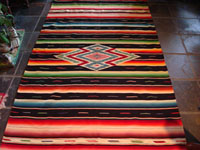 Mexican vintage textile, Saltillo sarape with black background and colorful silk center diamond, c. 1940.