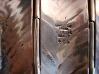 Closeup of Los Castillo silver cuff, showing signature.