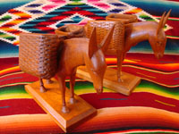 Mexican vintage wood-carvings, a pair of burros with baskets across their backs, c. 1940.