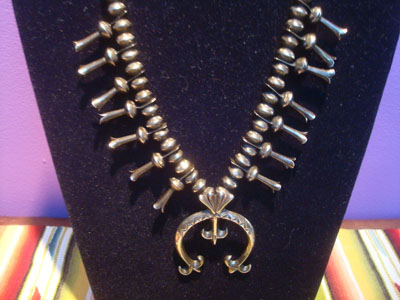 Native Amaerican vintege sterling silver jewelry, and Navajo vintage sterling silver jewelry, a beautiful squash blossom necklace, all silver with stamping on blossoms and Naja, Arizona or New Mexico, c. 1950's. Graceful and lovely, signed Begey. Closeup photo of the front of the necklace.