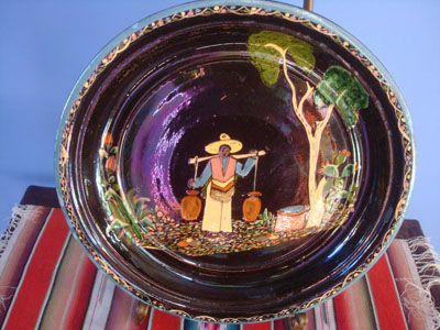 Mexican vintage pottery and ceramics a beautiful blackware plate of a scene of a paisano coming rom the well with full jarros (jars) of wate. Artwork crisp with good composition and colore glazs throughout plate which really enhances the artwork. Condition is very good. Size: 12 inches diameter. Price: $275.