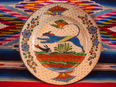 Mexican vintage pottery and ceramics, a very fine pottery plate featuring a leaping wolf, a blue bunny, butterflies and lovely foliage, with a starry-night background, from Tlaquepaque, Jalisco, c. 1920's. This is a fabulous plate and a collector's dream.