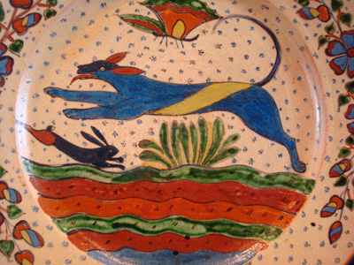 Mexican vintage pottery and ceramics, a very fine pottery plate featuring a leaping wolf, a blue bunny, butterflies and lovely foliage, with a starry-night background, from Tlaquepaque, Jalisco, c. 1920's. This is a fabulous plate and a collector's dream. The artwork is spectacular.