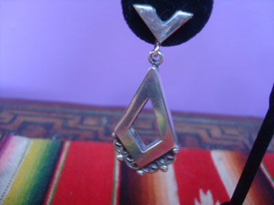 Mexican vintage sterling silver jewelry, and Taxco vintage sterling silver jewelry, a beautiful pair of dangling sterling silver earrings, Taxco, c. 1940's. The earrings are very graceful and elegant. Closeup photo of one earring.