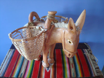 Mexican vintage folk art, a carved wooden donkey with woven baskets at both sides, Michoacan, c. 1980's.